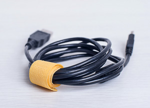 Computer cable wrapped with a tie for travel