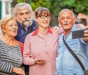 Four senior citizens taking a selfie on vacation