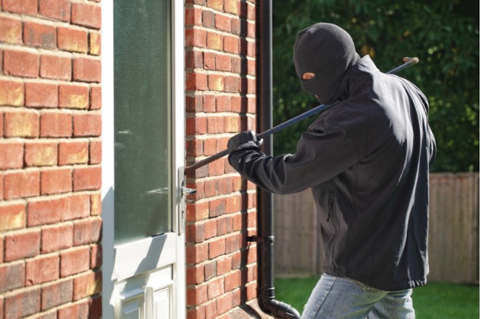 Man using a crowbar to break into a house