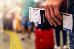 Man holding passport and boarding pass to get through security faster
