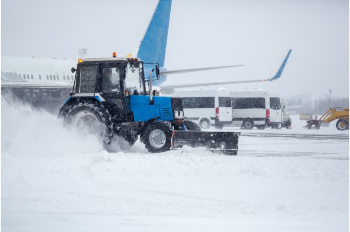 An airplane sitting on the tarmac delayed by snow.