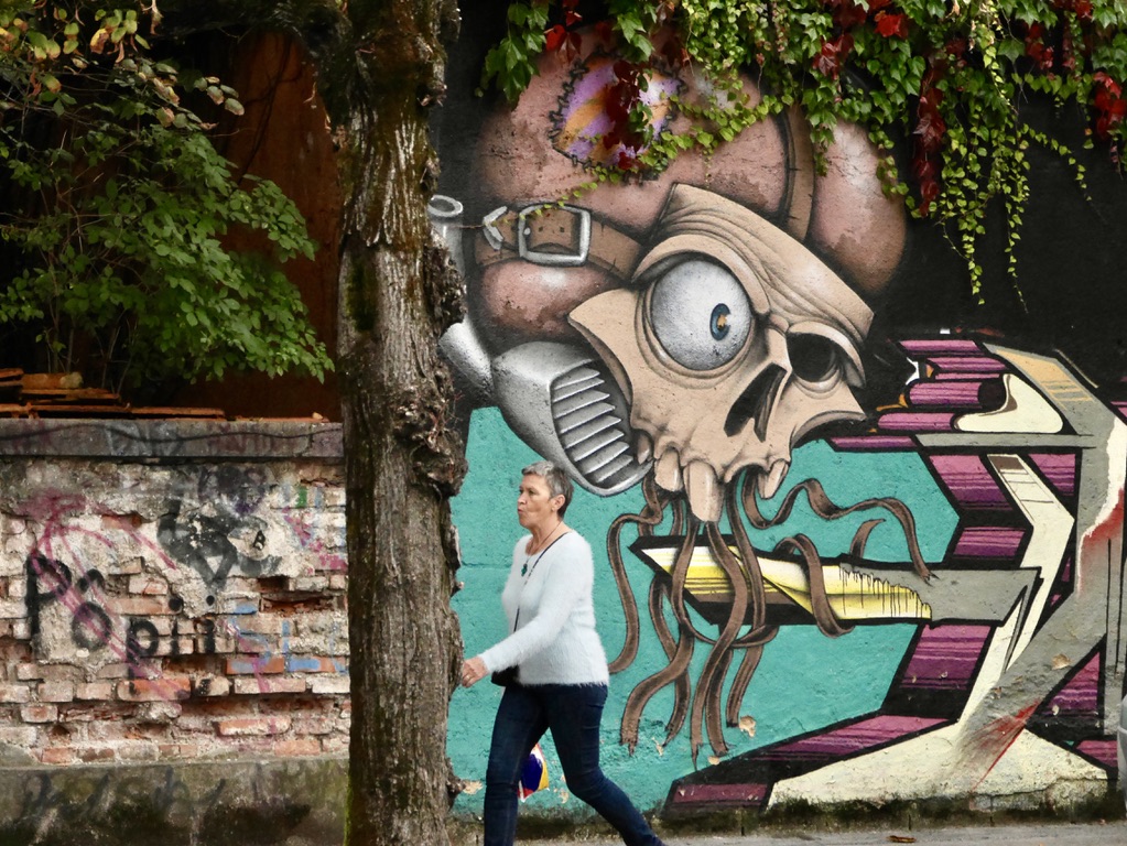 Woman walking past street art in Metalkova Slovenia