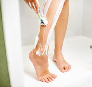 Woman shaving her leg with a disposable razor