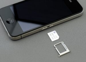 SIM card and holder laying by an iPhone