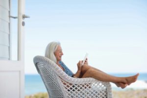 Woman relaxing at the beach with her cell phone