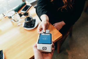 Woman paying by credit card in a cafe.