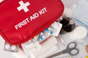 First aid kit for international travel showing pills, scissors, tape and bandages