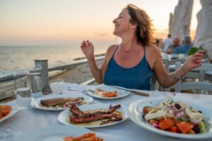 Woman enjoying a Greek meal overlooking the sea.