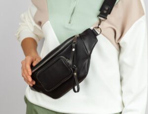 Black sling bag worn cross-body.