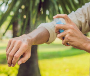 Person spraying natural insect repellent on their arm.