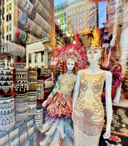 Two mannequin's dressed up with jeweled clothes and headdresses.